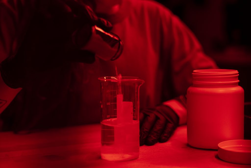 zensina-vid-speredi-prorabatyvaet-fotografii-v-temnoi-komnate